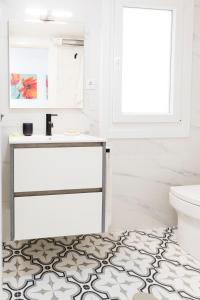 een badkamer met een witte wastafel en een toilet bij El rinconcito de la playa, parking incluido in Sanxenxo +23 foto's