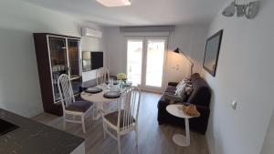 een woonkamer met een bank en een tafel met stoelen bij El rinconcito de la playa, parking incluido in Sanxenxo