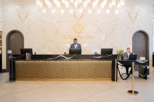 哈利法克斯The Sutton Place Hotel Halifax的两个人坐在桌子上,手提电脑