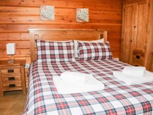 uma cama com duas almofadas num camarote em Watersview Lodge em Leek