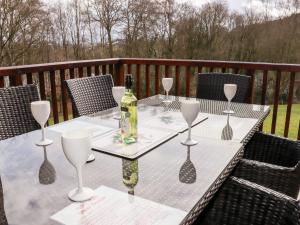 uma mesa com uma garrafa de vinho e copos de vinho em Watersview Lodge em Leek