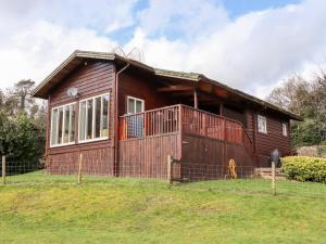 a small wooden house on a grassy field at Watersview Lodge in Leek