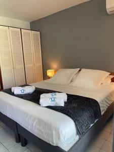 1 dormitorio con 1 cama con toallas en Kawann beach en Folle Anse