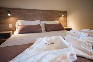 a bedroom with a bed with white towels on it at Altos del Champaqui in Villa Carlos Paz