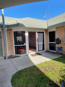 a home with a front door and a driveway at 1 bdrm Beach Apartment Papamoa in Papamoa