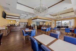 a dining room with tables and chairs and a kitchen at Best Western Plus Big America in Santa Maria