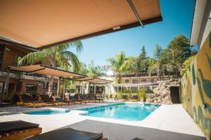 a swimming pool with lounge chairs and a resort at Altos del Champaqui in Villa Carlos Paz