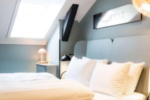 1 dormitorio con 1 cama con almohadas blancas en Scandic Oslo City, en Oslo