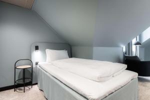 a bedroom with a large white bed and a stool at Scandic Oslo City in Oslo