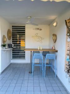 Folle Anse的住宿－Kawann beach，厨房配有桌子和蓝色凳子