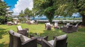 a group of chairs and tables in the grass at Rheinhotel Dreesen in Bonn
