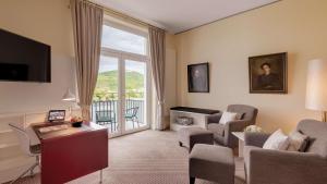 Rheinhotel Dreesen في بون: غرفة معيشة مع أريكة وكراسي ونافذة