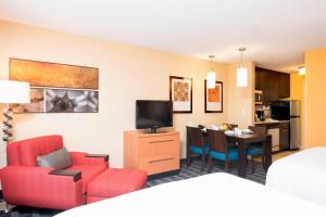 um quarto de hotel com uma sala de estar e de jantar em TownePlace Suites by Marriott Kalamazoo em Portage