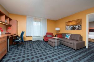 Habitación de hotel con sofá, sillas y escritorio. en TownePlace Suites by Marriott Kalamazoo, en Portage