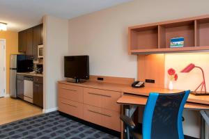 a room with a desk with a television and a desk sidx sidx sidx at TownePlace Suites by Marriott Kalamazoo in Portage