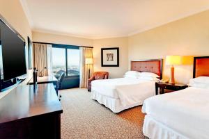 a hotel room with two beds and a flat screen tv at Sheraton Buenos Aires Hotel & Convention Center in Buenos Aires