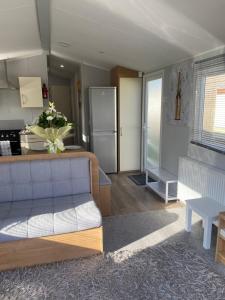 a living room with a couch and a kitchen at Stylish 3 Bedroom caravan near the Beach in Walton-on-the-Naze