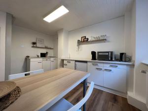 a kitchen with a wooden table and a counter top at Gemütliches Haus mit 2 Zimmern in Vallendar