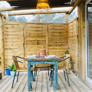 a blue table and chairs on a wooden patio at cabaña CasaOtto in Los Caños de Meca +18 photos