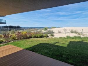 un patio con vistas a un campo de césped en Apartament ODNOWA z bezpośrednim widokiem na morze w Gardenia Dziwnów -, en Dziwnów