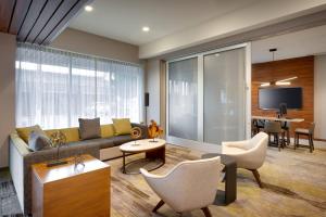 a living room with a couch and chairs and a table at Courtyard by Marriott Los Angeles LAX/Hawthorne in Hawthorne