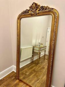 an ornate mirror with a table in a room at Luxury 2 BD, 2 BA on private gated Chigwell park in Chigwell