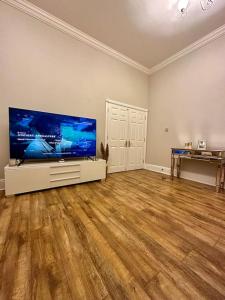 an empty living room with a large flat screen tv at Luxury 2 BD, 2 BA on private gated Chigwell park in Chigwell