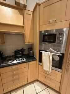a kitchen with a stove and a microwave at Luxury 2 BD, 2 BA on private gated Chigwell park in Chigwell