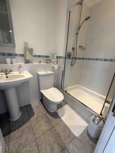 uma casa de banho com um WC, um chuveiro e um lavatório. em Luxury 2 BD, 2 BA on private gated Chigwell park em Chigwell