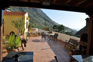 a balcony with a table and chairs and a mountain at Hotel Rural Villa de Hermigua in Hermigua +39 photos