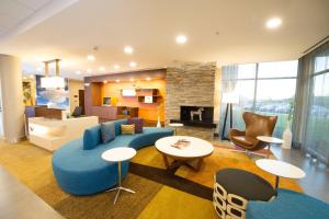 a large living room with a blue couch and chairs at Fairfield Inn & Suites by Marriott Dallas Plano North in Plano