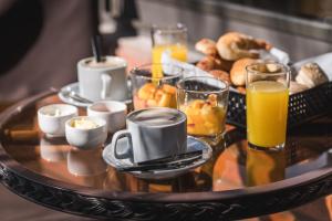 ヴィラ・カルロス・パスにあるAltos del Champaquiのテーブルの上に朝食用の食品とドリンクのトレイ