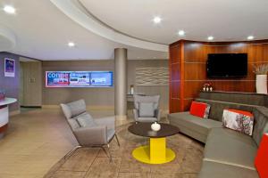 a lobby with a couch and chairs and a tv at SpringHill Suites by Marriott Madera in Madera
