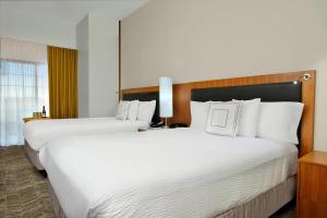 duas camas num quarto de hotel com lençóis brancos em SpringHill Suites by Marriott Madera em Madera