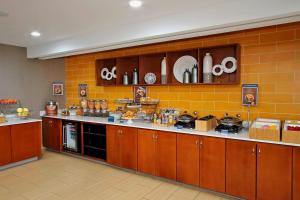 uma cozinha com armários castanhos e uma parede de tijolos amarelos em SpringHill Suites by Marriott Madera em Madera