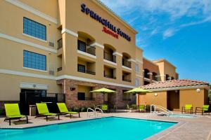 a hotel with a swimming pool in front of a building at SpringHill Suites by Marriott Madera in Madera