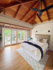 1 dormitorio con 1 cama grande y ventilador de techo en Sydney’s Northern Beaches Waterfront Paradise, en Clareville