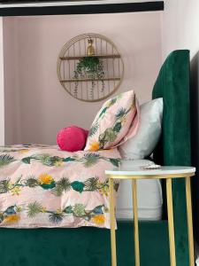 a bed with a pillow and a table at Hollie's Beach House in Peel