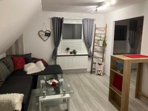 a living room with a couch and a glass table at Mellys Café & Store in Einbeck