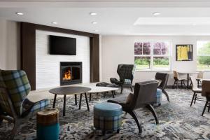 vestíbulo con chimenea, sillas y mesa en Residence Inn by Marriott Harrisburg Carlisle, en Carlisle