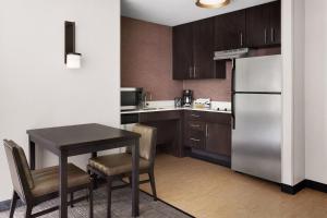 a small kitchen with a table and a refrigerator at Residence Inn by Marriott Harrisburg Carlisle in Carlisle