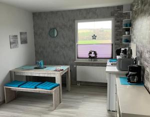 a kitchen with two tables and a sink and a window at Mellys Café & Store in Einbeck