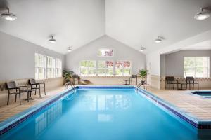 a pool in a room with chairs and a table at Residence Inn by Marriott Harrisburg Carlisle in Carlisle