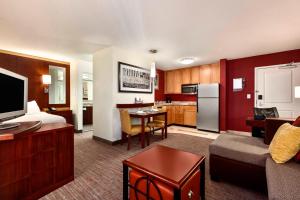 a hotel room with a kitchen and a living room at Residence Inn by Marriott Greensboro Airport in Greensboro