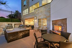 a patio with tables and chairs and a fireplace at TownePlace Suites by Marriott Austin Northwest The Domain Area in Austin