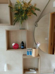 a bathroom with a mirror and a vase with flowers at A los Ojos del Río Duero in Zamora