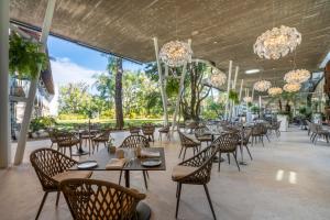 クエルナバカにあるAnticavilla Hotel Restaurante & Spaのテーブルと椅子、シャンデリアのあるレストラン
