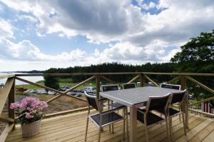 terraza de madera con mesa y sillas en el balcón en Skärgårdsbyn S:t Anna, en Mon