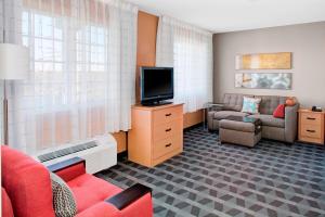 sala de estar con TV y sofá en TownePlace Suites Wichita East, en Wichita