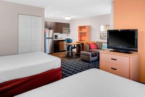 a hotel room with two beds and a flat screen tv at TownePlace Suites Wichita East in Wichita